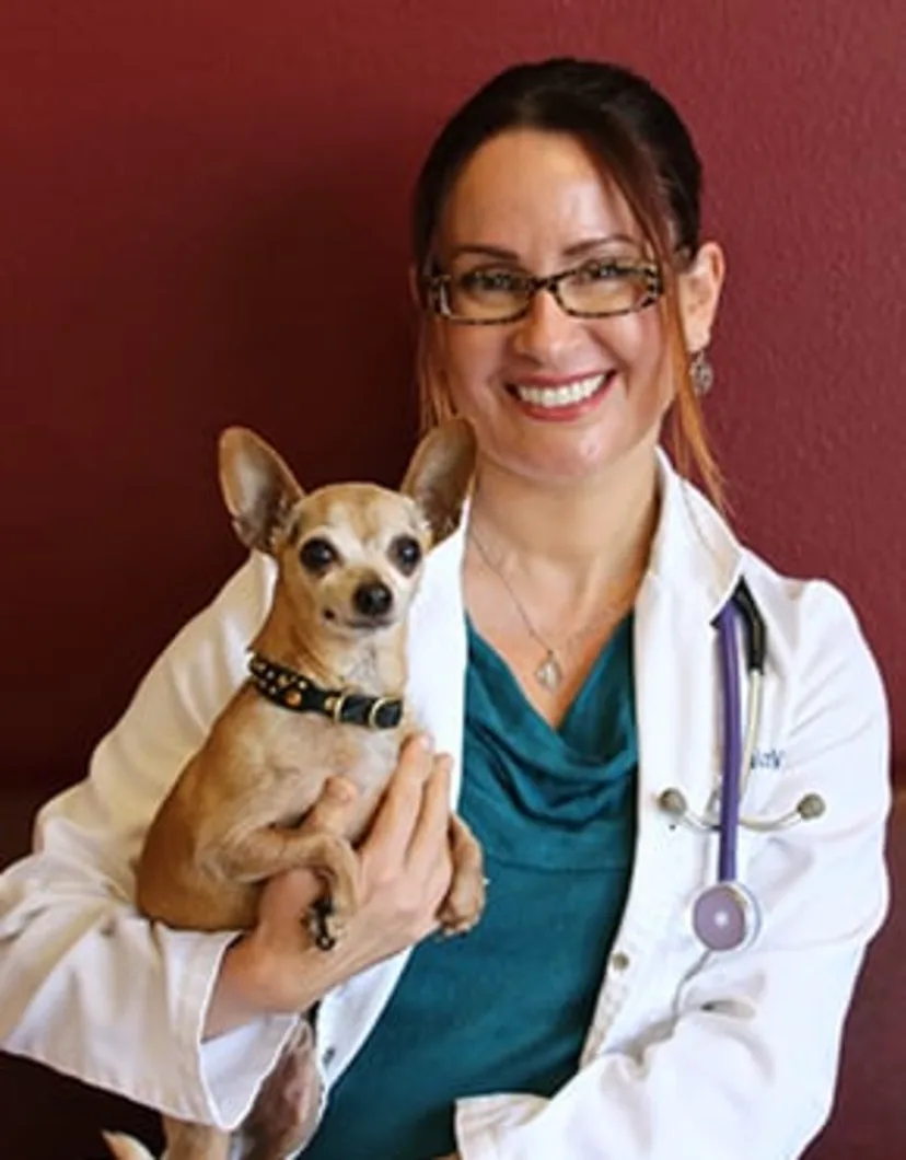 Dr. Malena Arvizu smiling while holding a dog 
